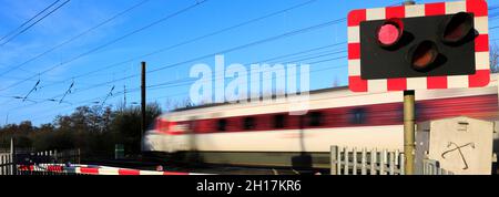 Treno Azuma che passa luci rosse a un incrocio senza equipaggio, East Coast Main Line Railway, Peterborough, Cambridgeshire, Inghilterra, Regno Unito Foto Stock