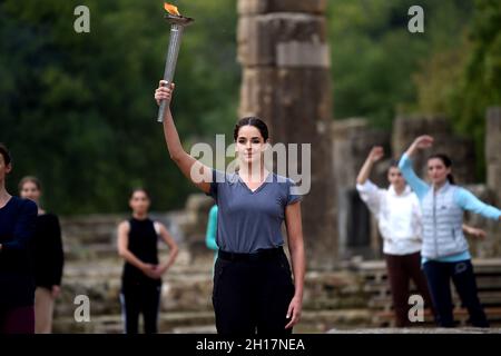 Olympia, Grecia. 17 ottobre 2021. L'attrice greca Xanthi Georgiou, che gioca il ruolo dell'alta Priestessa, tiene la torcia durante la prova di vestito per l'illuminazione della fiamma olimpica nell'antica Olimpia, il luogo di nascita degli antichi Giochi Olimpici. La fiamma sarà trasportata da una torcia a Pechino, in Cina, dove le Olimpiadi invernali avranno luogo dal 4 al 20 febbraio 2022. Credit: Angelos Tzortzinis/dpa/Alamy Live News Foto Stock