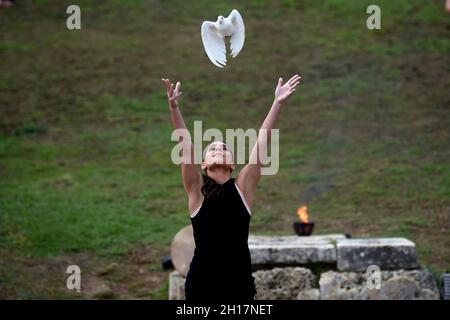 Olympia, Grecia. 17 ottobre 2021. Un performer rilascia una colomba bianca durante la prova di vestito per l'illuminazione della fiamma olimpica nell'antica Olimpia, il luogo di nascita degli antichi Giochi Olimpici. La fiamma sarà trasportata da un relè di torcia a Pechino, in Cina, dove si terranno le Olimpiadi invernali dal 4 al 20 febbraio 2022. Credit: Angelos Tzortzinis/dpa/Alamy Live News Foto Stock