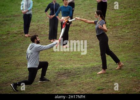 Olympia, Grecia. 17 ottobre 2021. L'attrice greca Xanthi Georgiou, che gioca il ruolo dell'alta Priestessa, consegna la fiamma al primo torchbearer greco, sciatore di fondo Ioannis Antoniou, durante le prove di vestito per l'illuminazione della fiamma olimpica nell'antica Olimpia, il luogo di nascita degli antichi Giochi Olimpici. La fiamma sarà trasportata da una torcia a Pechino, in Cina, dove le Olimpiadi invernali avranno luogo dal 4 al 20 febbraio 2022. Credit: Angelos Tzortzinis/dpa/Alamy Live News Foto Stock