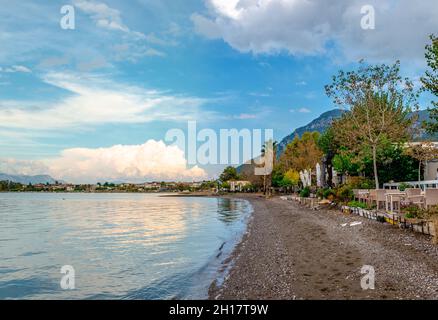 La spiaggia vuota in autunno. Tramonto cielo drammatico, riflessi sull'acqua. Foto Stock