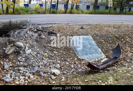 abbattuto post rotto vetro e paraurti in scena di un incidente auto sulla strada della città Foto Stock