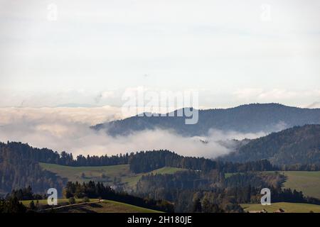 17 ottobre 2021, Baden-Wuerttemberg, St. Märgen: Un tappeto di nuvole si trova tra le colline pedemontane della Foresta Nera e sulla valle del Reno, mentre i pendii soprastanti sono bagnati dalla luce del sole. Foto: Philipp von Ditfurth/dpa Foto Stock