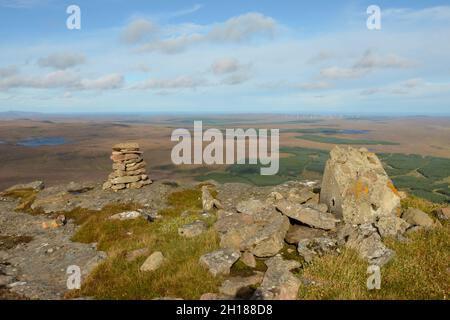 Un cairn di pietra e punto di trig di OS rotto sulla cima della collina ben Griam Beg nella foresta di Achentoul, Highlands scozzesi, Regno Unito Foto Stock