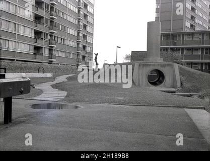 1960, storico, un parco giochi in cemento e murato, in un grande complesso residenziale del consiglio, Churchill Gardens a Pimlico, Inner London, Inghilterra, Regno Unito. Costruito negli anni del dopoguerra tra il 1948 e il 1962 per sostituire le terrazze vittoriane danneggiate nel Blitz della seconda Guerra Mondiale, questo era un'enorme proprietà di alloggi sociali, con 32 blocchi torre che forniscono 1,600 case. All'esterno degli appartamenti, un'area giochi in cemento con tunnel e imbuto. Foto Stock