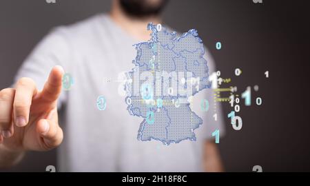 Un uomo sta toccando la mappa della Germania che consiste di triangoli di rendering 3D, linee Foto Stock
