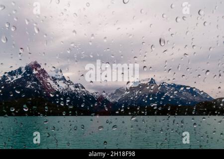 Gocce d'acqua sulla finestra di una barca che attraversa il lago di Pehoe di fronte al Cuernos del Paine. Ultima Esperanza Cile Foto Stock