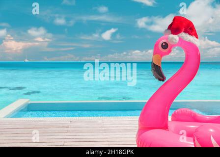 Spiaggia di Natale estate vacanza flamingo piscina galleggiante con babbo natale sfondo viaggio per le vacanze invernali Foto Stock