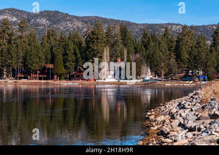 Le case e gli alberi sempreverdi si riflettono sul lago Big Bear. Big Bear Lake, California, Stati Uniti. Foto Stock