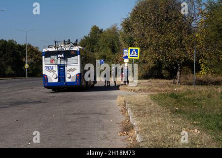 Chisinau, Moldavia - 10 ottobre 2021: Passeggeri in maschera di protezione in attesa di imbarco sul filobus elettrico durante la quarantena del virus corona. Foto Stock