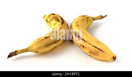 Banane mature isolate su sfondo bianco. Frutta con macchie scure che iniziano a rovinare. Foto Stock