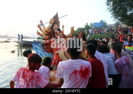 Non esclusiva: I devoti indù immergono un idolo di argilla della dea indù Durga nel fiume Buriganga durante l'ultimo giorno del festival Durga Puja. T Foto Stock