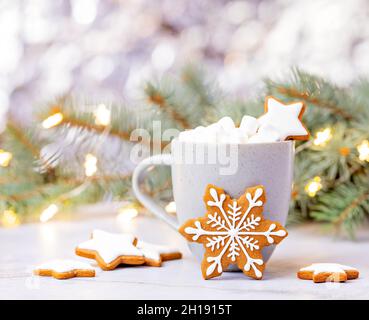 Carino Natale Snowflake Gingerbread cookie di fronte a una tazza di cioccolata calda con Marshmallows. Foto Stock