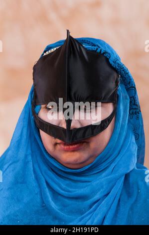 Ritratto di una donna beduina che indossa una maschera facciale tradizionale. Wahiba Sands, Oman. Foto Stock