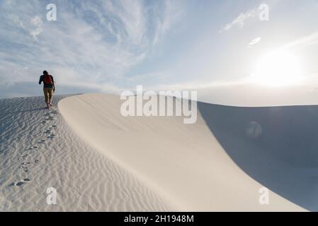 Un uomo che cammina lungo le dune di sabbia al White Sands National Park di Alamogordo, New Mexico. Foto Stock