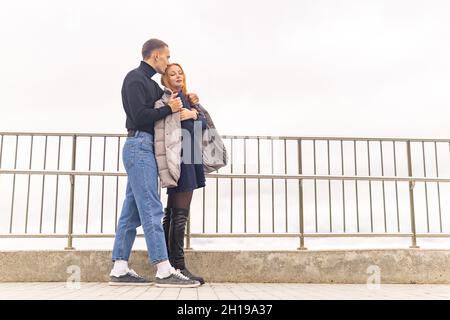 coppia innamorata, il ragazzo mette la sua giacca sulle spalle della ragazza in tempo freddo Foto Stock