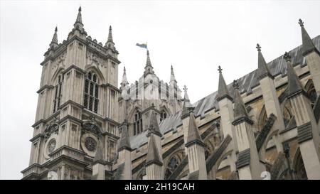 Vista dal basso sull'esterno dell'Abbazia di Westminster contro il cielo nuvoloso grigio. Si tratta di una grande chiesa abbaziale principalmente gotica nella Città del W. Foto Stock