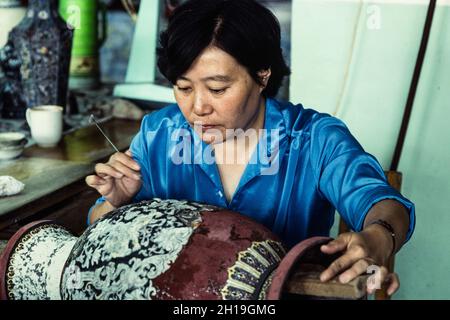 Un artigiano lavora su un vaso cloissone prima del primo fuoco in un laboratorio a Pechino, Cina. Foto Stock