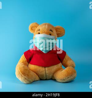 Heraklion, Grecia, 13 marzo 2020: Composizione creativa con orso giallo con maschera virus. Epidemia minima di virus Corona. Concetto di vacanza. Foto Stock