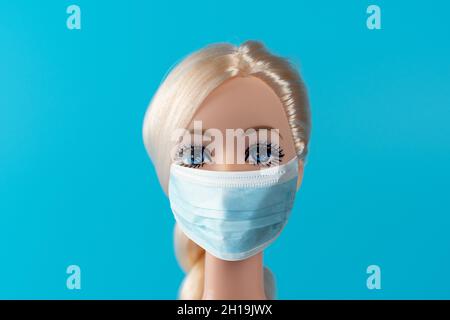 Heraklion, Grecia, 13 marzo 2020: Composizione creativa con bambola con maschera virus. Epidemia minima di virus Corona. Concetto di vacanza. Foto Stock