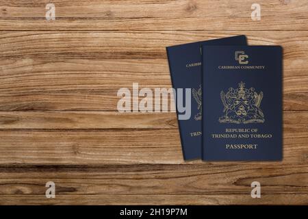 I passaporti di Trinidad e Tobago sono rilasciati ai cittadini di Trinidad e Tobago per i viaggi internazionali, due passaporti su sfondo di legno Foto Stock