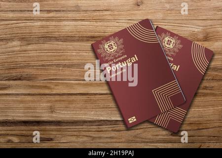 I passaporti portoghesi sono rilasciati ai cittadini del Portogallo ai fini di viaggi internazionali, passaporto portoghese su sfondo di legno Foto Stock