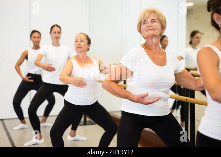 Le donne che esercitano il balletto si muove in aula di formazione Foto Stock