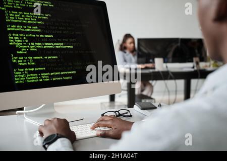 Primo piano dello sviluppatore di software afroamericano che scrive il codice mentre usa il computer in ufficio, spazio di copia Foto Stock