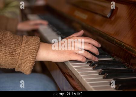 Primo piano delle mani femminili che suonano il pianoforte. Foto Stock