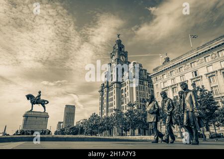 I Beetles sul lungomare di Liverpool di fronte al Three Graces - il Royal Liver Building, il Cunard Building e il Port of Liverpool Building. Foto Stock