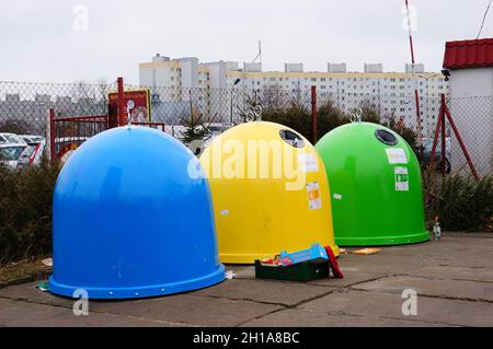 POZNAN, POLONIA - 25 gennaio 2015: Una fila dei contenitori colorati di rifiuti ordinati sulla strada nella città di Poznan Foto Stock