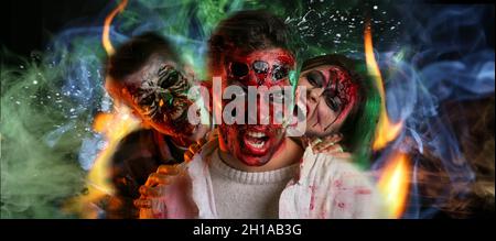 Zombie spaventose su sfondo scuro con fiamme e fumo brucianti Foto Stock