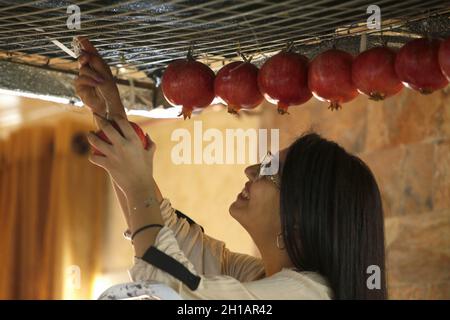 Nablus, Palestina. 17 ottobre 2021. La donna samaritana ha visto appendere frutta e agrumi in preparazione alla tradizionale festa conosciuta come Sikka. I samaritani si preparano per la festa del Trono, conosciuta come Sikka, sul monte Gerizim nella città di Nablus, in Cisgiordania. La setta samaritana è considerata la più piccola denominazione del mondo, con 800 membri. (Foto di Nasser Ishtayeh/SOPA Images/Sipa USA) Credit: Sipa USA/Alamy Live News Foto Stock