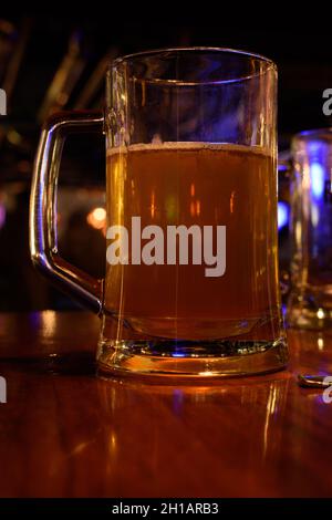 Primo piano di un bicchiere di birra su uno sfondo sfocato del pub. Messa a fuoco selettiva Foto Stock