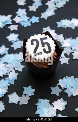 Numero 25 su deliziosa cupcake al cioccolato con crema su sfondo scuro. Muffin. Festa della torta di compleanno. Torta al cioccolato fatta in casa. annivers di 25 anni Foto Stock