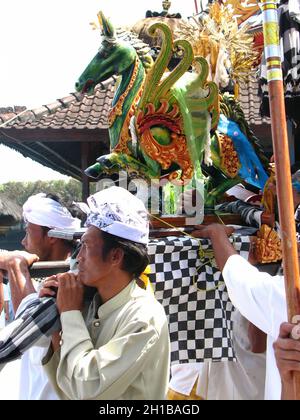 Le persone con statua in legno di cavallo verde alato in evento rituale balinese sfilano al tempio indù di Bali, Indonesia. Popolare attrazione turistica. Foto Stock