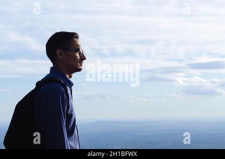 escursionista che guarda l'orizzonte sulla cima della montagna. serio giovane uomo che pensa fuori. concetto di libertà e libertà Foto Stock