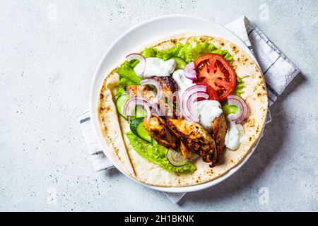 Cucina gyros di pollo con verdure e salsa tzatziki, vista dall'alto. Concetto di cibo greco. Foto Stock