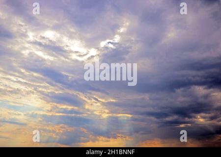 I raggi del sole si infrangono attraverso le nuvole scure. Foto Stock