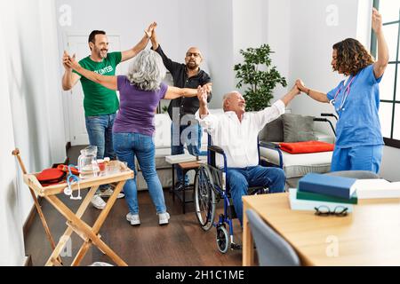 Gruppo di pensionati che hanno partito ballando con il medico e volontario a casa di infermiera. Foto Stock