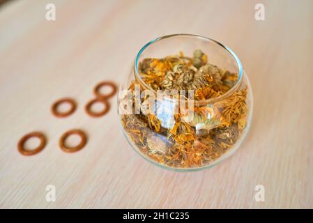 Un vaso con fiori di marigold secchi si trova su un tavolo Foto Stock