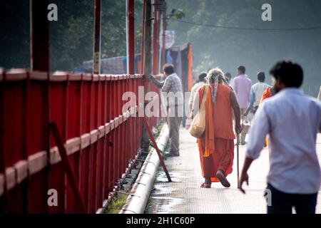 Haridwar, Uttarakhand - circa 2021 : il sadhu santo indiano monk che cammina su un ampio percorso indossando i vestiti dello zafferano dell'induismo nella città Santa di Haridwa Foto Stock