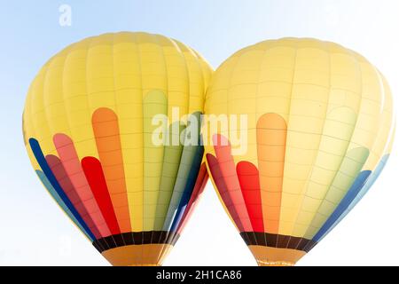 due palloncini con aria calda nei colori verde, blu, rosso e giallo Foto Stock