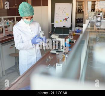 Operatore di laboratorio che lavora con la pipetta automatica in laboratorio Foto Stock