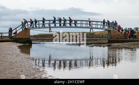 Belhaven Bay, East Lothian, Scozia, Regno Unito, 18 ottobre 2021. Pellegrinaggio del Cop26: Dopo una sosta a Dunbar, gli attivisti cristiani del clima iniziano sulla prima tappa della Via John Muir. Attraversano il Ponte fino a Nowhere e camminano attraverso la spiaggia con la bassa marea. Il pellegrinaggio si porterà a COP26 a Glasgow entro la fine del mese Foto Stock