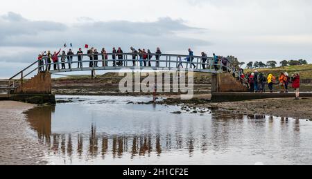 Belhaven Bay, East Lothian, Scozia, Regno Unito, 18 ottobre 2021. Pellegrinaggio del Cop26: Dopo una sosta a Dunbar, gli attivisti cristiani del clima iniziano sulla prima tappa della Via John Muir. Attraversano il Ponte fino a Nowhere e camminano attraverso la spiaggia con la bassa marea. Il pellegrinaggio si porterà a COP26 a Glasgow entro la fine del mese Foto Stock