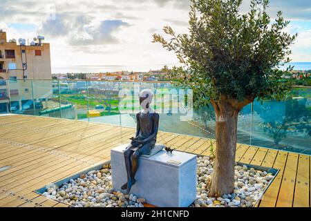 Paphos, CIPRO - 15 FEBBRAIO 2019: La scultura della ragazza e della Sparrow al punto di vista turistico, skyline aereo con paesaggio urbano e cielo nuvoloso Foto Stock