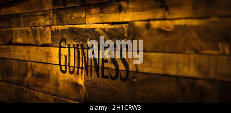 Dublino, Irlanda, dicembre 2017 attenzione selettiva al segno Guinness in stile vintage o grungy su tavole di legno. Guinness è l'iconica birra irlandese Foto Stock