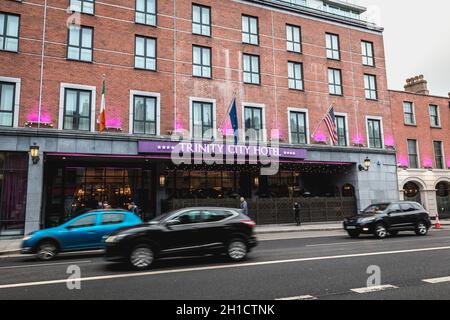 Dublino, Irlanda - 11 febbraio 2019: Persone e auto che passano davanti alla facciata del lussuoso Trinity City Hotel nel centro della città in una giornata invernale Foto Stock