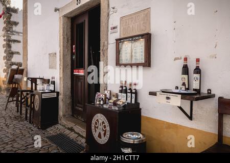 Obidos, Portogallo - 12 aprile 2019: Mostra di un negozio specializzato nella vendita di ginjinha o ginja, tradizionale liquore a base di ciliegia nella storica c Foto Stock